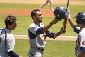 Pepperdine's Austin Davidson is congratulated by teammates after scoring the game's first run. By Owen Main